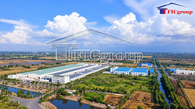 Aerial view of modern industrial factories and warehouses in Vietnam, surrounded by green landscapes and transportation infrastructure.